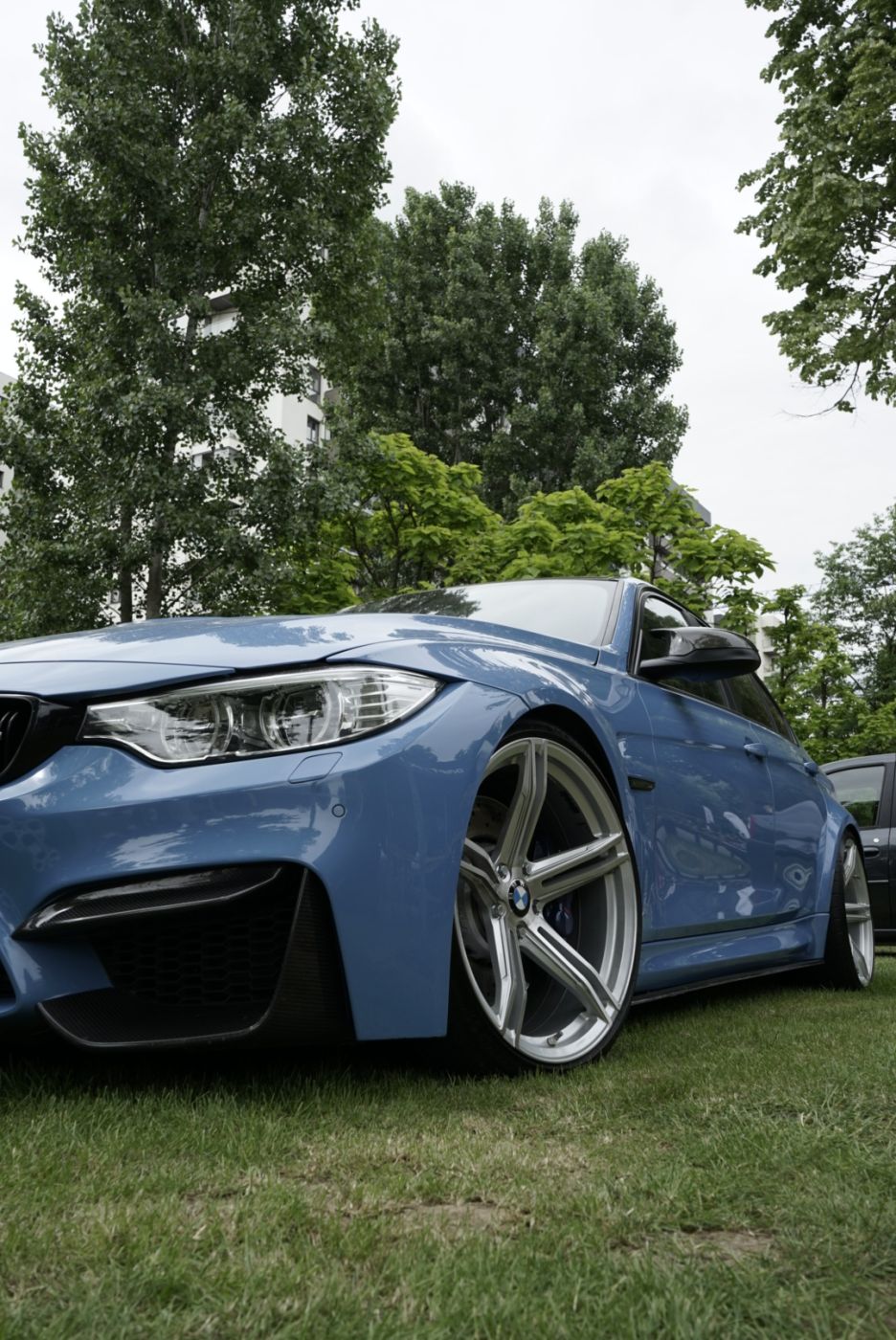 BMW albastru, detaliu față cu far și jantă
