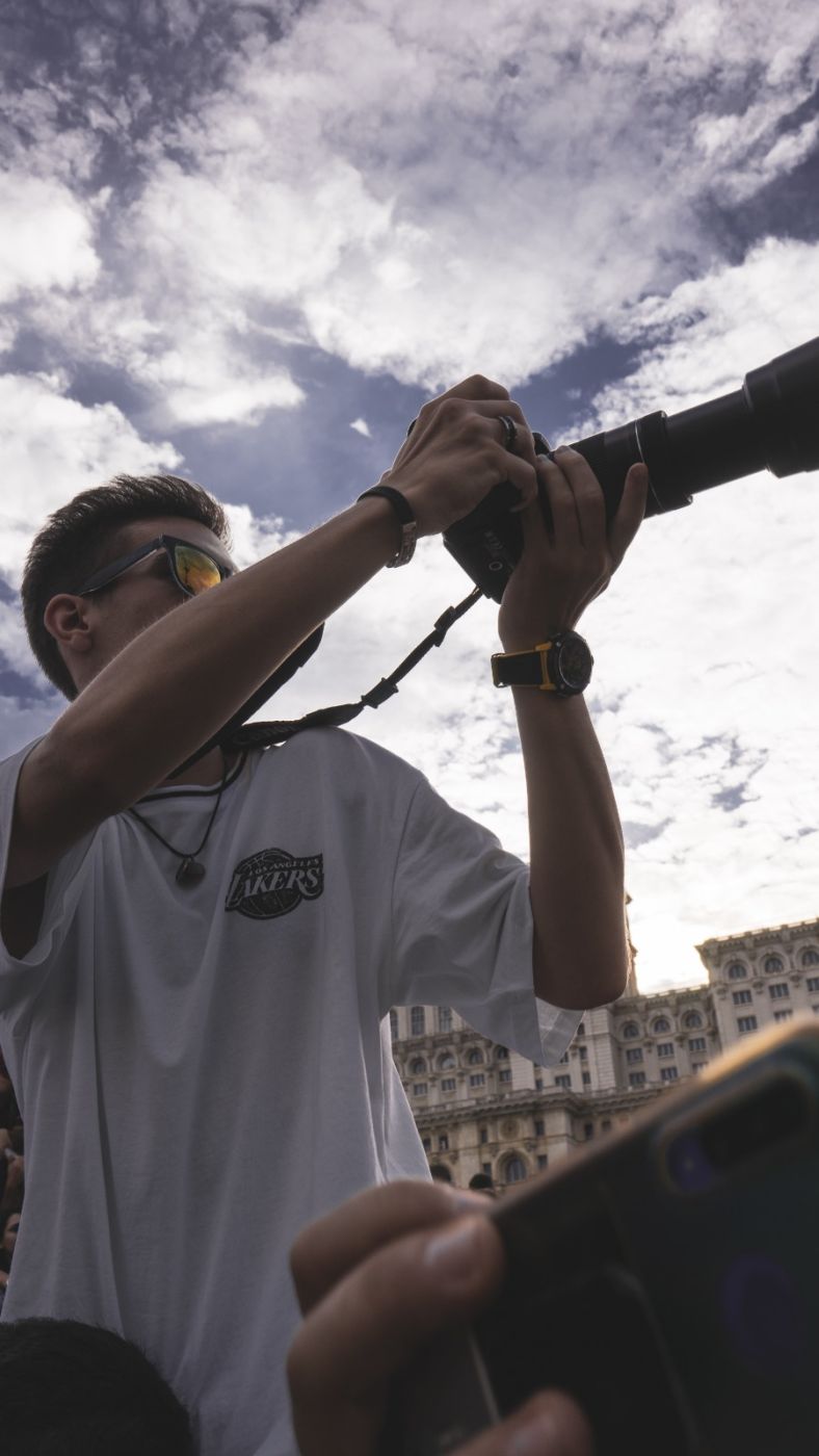 Videograful HAUS Media Production filmând un eveniment în aer liber, în mulțime